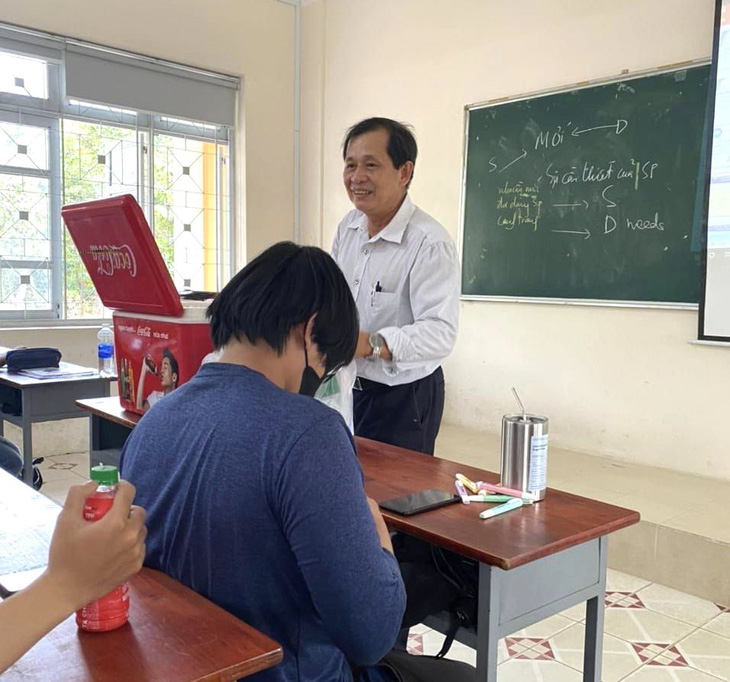 Giảng viên - tiến sĩ Lê Quang Thông mang nước đến lớp phát tặng sinh viên - Ảnh: Cộng Đồng Sinh Viên Đại Học Nông Lâm TP.HCM