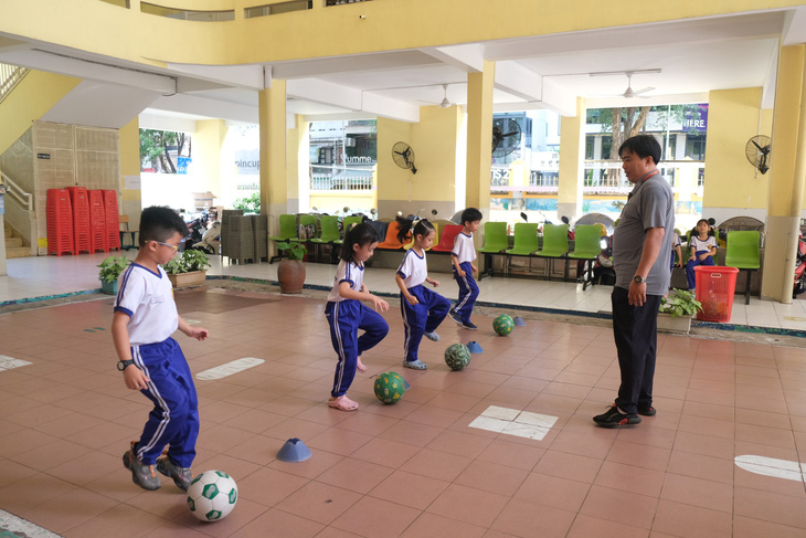 Học sinh Trường tiểu học Nguyễn Bỉnh Khiêm, quận 1, TP.HCM học thể dục ở khu vực sảnh của trường để tránh nắng nóng - Ảnh: NGỌC PHƯỢNG
