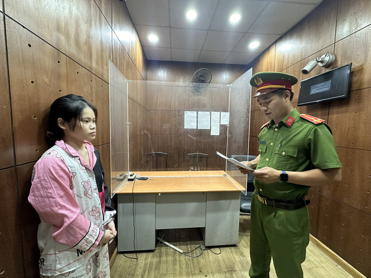 Phạm Huỳnh Nhật Vi (trái) nghe đọc lệnh bắt tạm giam - Ảnh: Công an cung cấp