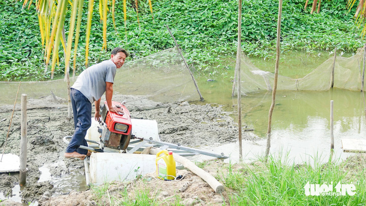 Ông Dương tranh thủ mót nước ngọt bơm vào 20 công đất của gia đình nuôi tôm càng xanh - Ảnh: CHÍ CÔNG