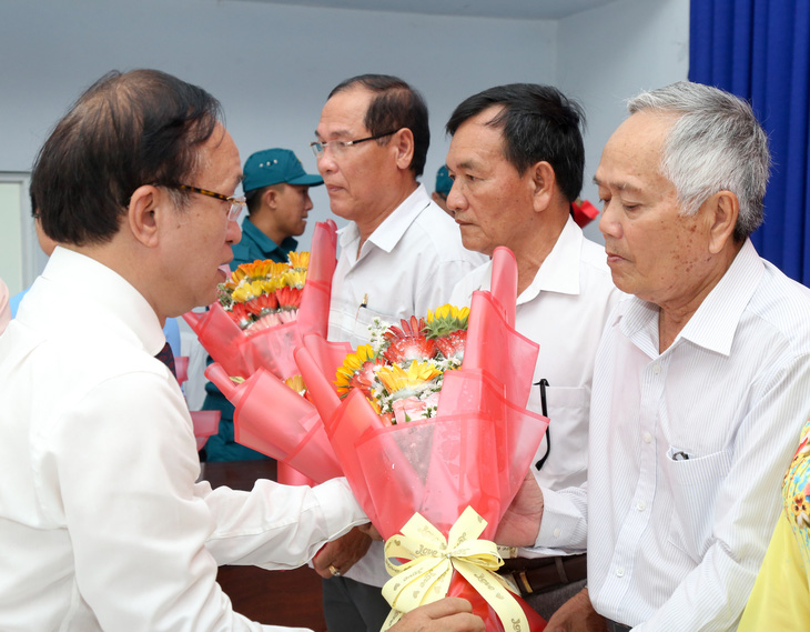 Bí thư Huyện ủy huyện Cần Giờ Nguyễn Phước Hưng tặng hoa các cán bộ không chuyên trách được cử giữ chức vụ ở ấp mới - Ảnh: THẢO LÊ