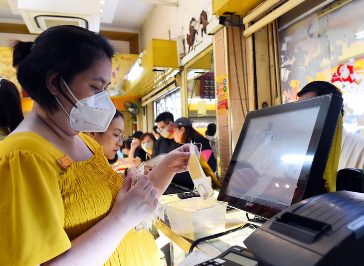 Người dân mua vàng tại một cửa hàng ở chợ Bà Chiểu, quận Bình Thạnh, TP.HCM - Ảnh: TỰ TRUNG