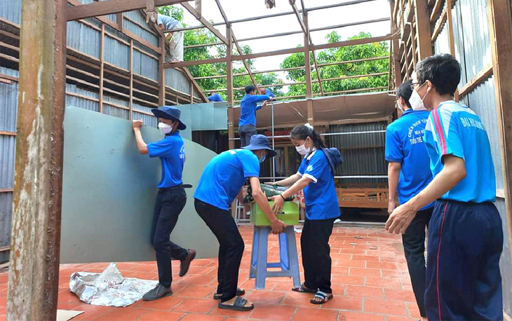 Sinh viên tình nguyện Trường ĐH Đồng Tháp cùng góp công xây nhà tặng bạn mình - Ảnh: D.THU