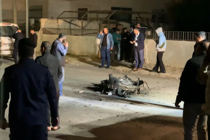 Người dân và lực lượng an ninh đứng xung quanh mảnh vỡ của một tên lửa mà lực lượng Jordan đã đánh chặn trên bầu trời thủ đô Amman (Jordan), trong bối cảnh Iran tấn công Israel bằng tên lửa và drone vào rạng sáng 14-4 - Ảnh: AFP