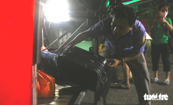Nhân viên ga Tuy Hòa hỗ trợ hành khách sắp xếp hành lý lên xe trung chuyển vào khuya 13-4 - Ảnh: NGUYỄN HOÀNG
