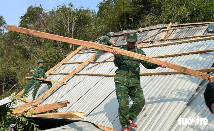 Các chiến sĩ đồn Biên phòng Nhôn Mai giúp người dân khắc phục hậu quả sau trận mưa đá kèm dông lốc xảy ra trên địa bàn huyện Tương Dương vào chiều 13-4 - Ảnh: HẢI THƯỢNG