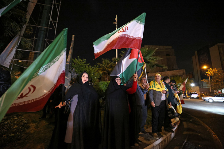 Nhiều người vẫy cờ Iran và Palestine tập trung tại Quảng trường Palestine ở thủ đô Tehran vào ngày 14-4, sau khi Iran tiến hành tấn công Israel - Ảnh: AFP