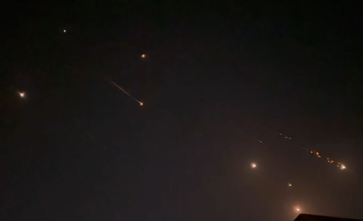 Bầu trời tại thành phố Hebron ở Bờ Tây sáng rực ngày 14-4 trong khi Iran không kích Israel - Ảnh: AFP