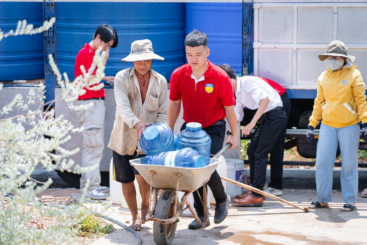 Các bạn sinh viên hỗ trợ mang nước sạch về tận nhà cho bà con vùng hạn mặn tỉnh Tiền Giang - Ảnh: NVCC