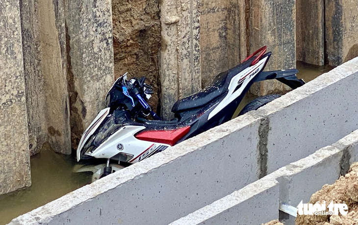 Chiếc xe máy của nạn nhân nằm gọn dưới hố công trình - Ảnh: DOÃN HÒA