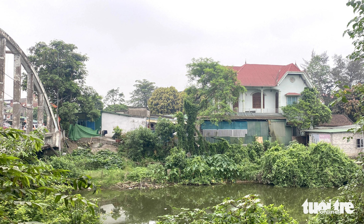 Căn nhà hai tầng mái ngói đỏ phải bỏ hoang do không còn lối đi vào - Ảnh: DOÃN HÒA