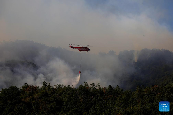 Hơn 2.300 người đang chiến đấu với đám cháy rừng ở tỉnh Vân Nam, tây nam Trung Quốc từ hôm 12-4. Trong ảnh, một chiếc trực thăng chữa cháy đối phó cháy rừng ở Côn Minh, tỉnh Vân Nam hôm 14-4 - Ảnh: TÂN HOA XÃ