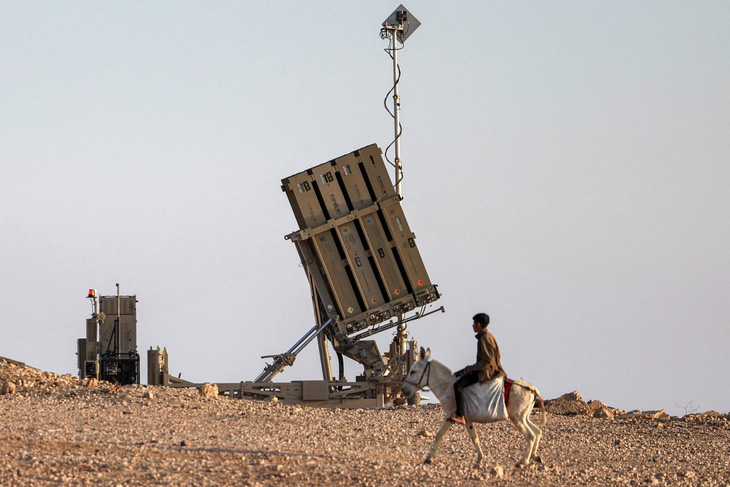 Một cậu bé cưỡi lừa gần hệ thống phòng thủ tên lửa Iron Dome (Vòm sắt) của Israel tại một ngôi làng ở sa mạc Negev hôm 14-4 - Ảnh: AFP