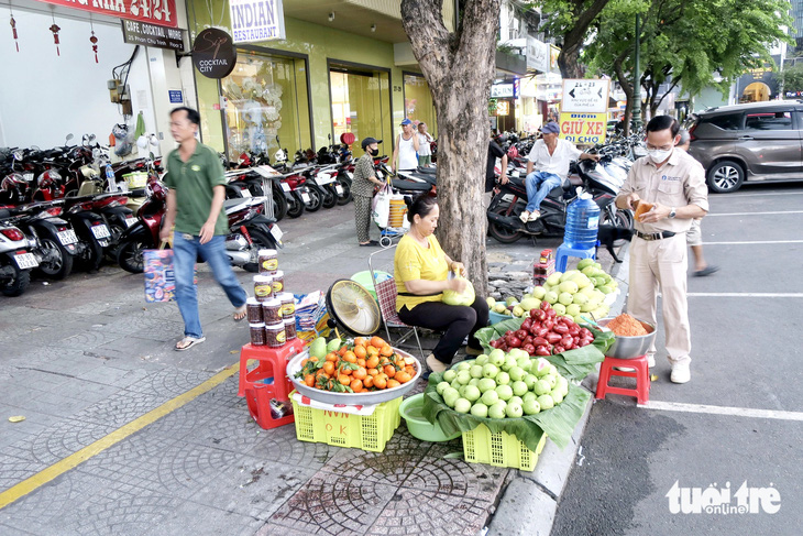 Các tiểu thương hàng rong vẫn chưa biết được phép bán ở khu vực nào sau khi có vạch kẻ vàng trên đường Phan Chu Trinh, quận 1, TP.HCM - Ảnh: T.T.D.