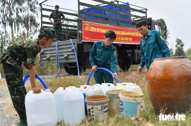 Lực lượng vũ trang tỉnh Kiên Giang dùng xe chở nước ngọt cho hàng trăm hộ dân xã Phú Mỹ, huyện Giang Thành - Ảnh: PHƯƠNG VŨ