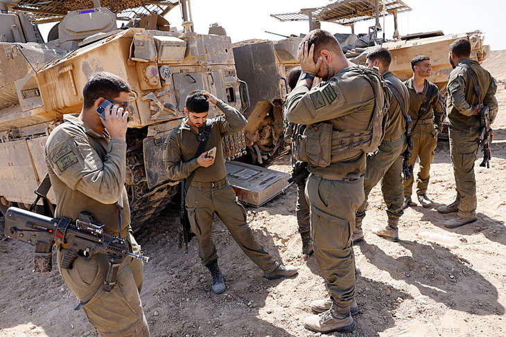 Binh sĩ Israel đứng cạnh các xe quân sự gần biên giới với Gaza vào ngày 15-4 - Ảnh: Reuters