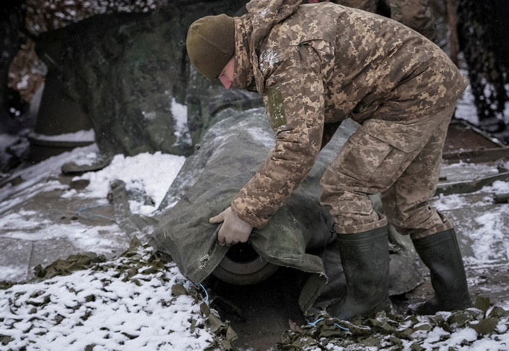 Quân nhân Ukraine ngụy trang pháo tự hành gần thị trấn Chasiv Yar ở vùng Donetsk - Ảnh: REUTERS