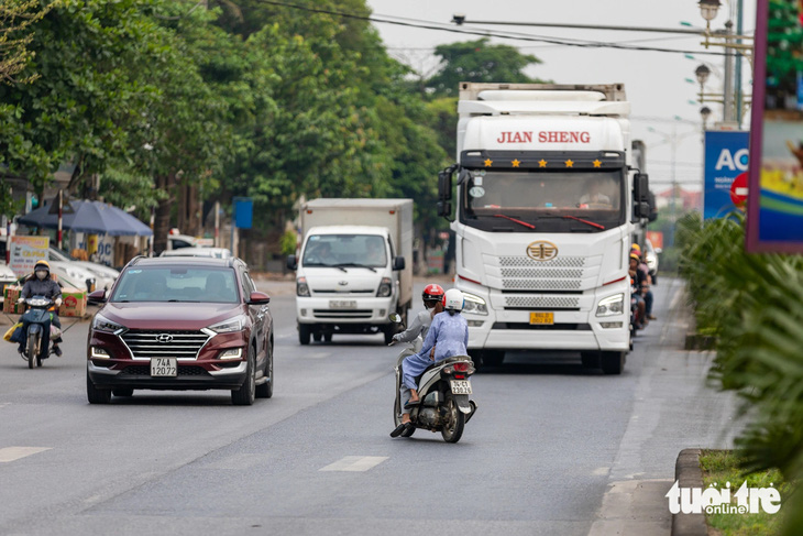 Một người đi xe máy tìm cách qua đường trên quốc lộ 1 đoạn qua TP Đông Hà, Quảng Trị - Ảnh: HOÀNG TÁO