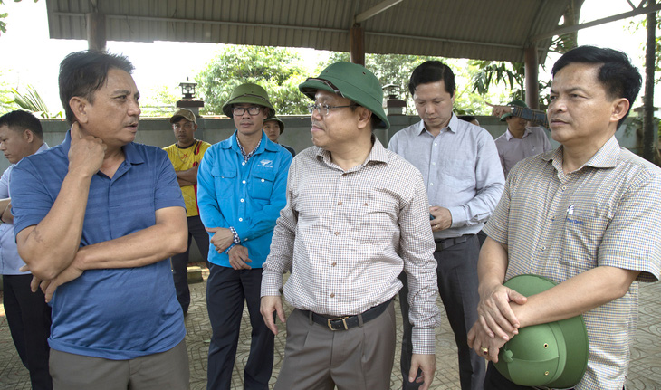 Ông Lê Đức Tiến (giữa) - phó chủ tịch UBND tỉnh Quảng Trị - trao đổi với ông Nguyễn Vĩnh (trái), một trong ba hộ dân vướng khó để bàn phương án giải quyết - Ảnh: HOÀNG TÁO