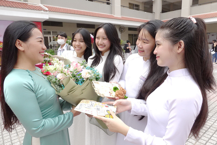 Học sinh Trường THPT Nguyễn Hữu Thọ, quận 4, TP.HCM tặng hoa cô giáo chúc mừng Ngày Nhà giáo Việt Nam - Ảnh: NHƯ HÙNG