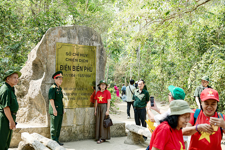 Các đoàn khách chụp ảnh tại di tích Sở chỉ huy chiến dịch Điện Biên Phủ tại Mường Phăng - Ảnh: NAM TRẦN