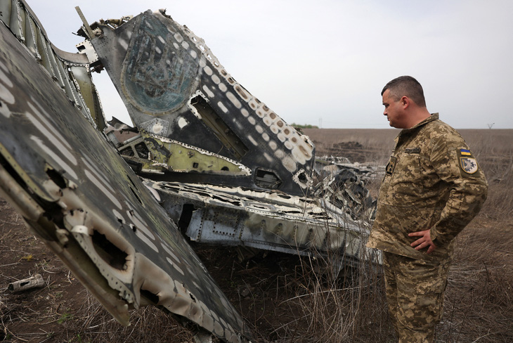 Trung tá Serhiy Verbytsky của Ukraine bên cạnh phần còn lại của chiếc máy bay SU-24M do ông cầm lái ở vùng Kharkov, Ukraine, ngày 17-4 - Ảnh: AFP