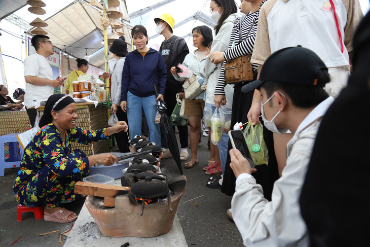 Ngay đầu khu vực lễ hội, gian hàng bánh bò nướng của người Chăm thu hút rất đông khách tham quan, ghi hình - Ảnh: CHÍ QUỐC