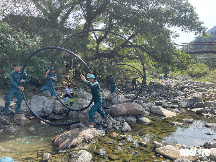 Lực lượng dân quân xã Đạ M'ri, huyện Đạ Huoai (Lâm Đồng) dẫn ống vào rừng tiếp nước cho trạm lọc - Ảnh: HẢI ĐƯỜNG