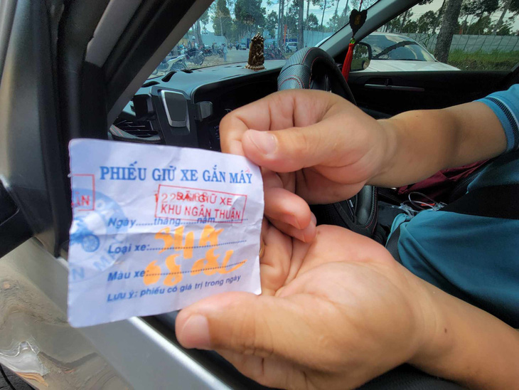 Một tài xế ở Bạc Liêu đến Lễ hội bánh dân gian Nam Bộ trưa 18-4 cho biết anh bị "chém" giá giữ xe tới 50.000 đồng/lượt. Người giữ xe đưa cho anh phiếu giữ xe gắn máy - Ảnh: CHÍ QUỐC
