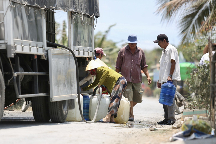Do thời tiết nắng nóng kéo dài, xâm nhập mặn gay gắt, người dân tỉnh Tiền Giang xếp hàng lấy nước ngọt sinh hoạt - Ảnh: PHƯƠNG QUYÊN