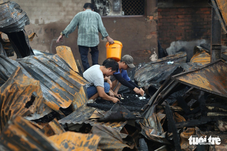 Người dân tìm kiếm tài sản còn sót lại sau vụ cháy - Ảnh: MINH HÒA