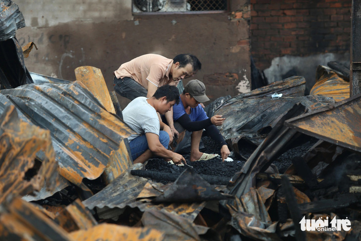Nhiều người đào bới tại hiện trường vụ cháy - Ảnh: MINH HÒA