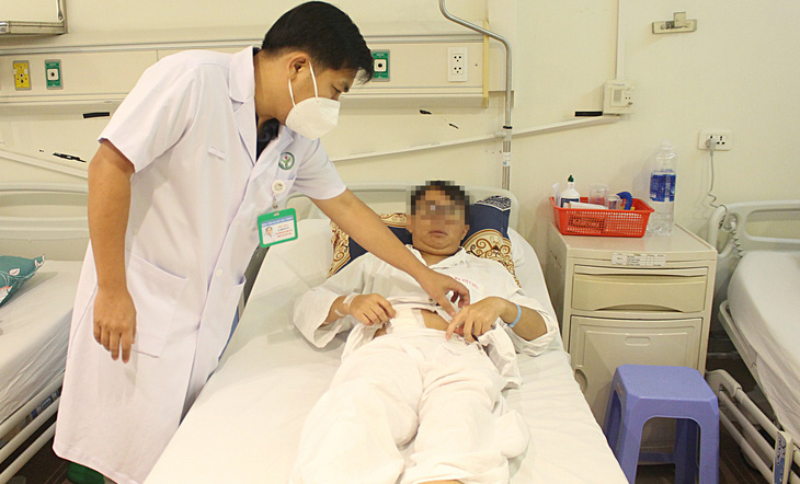 Bác sĩ Bệnh viện Việt Đức thăm khám bệnh nhân sau ghép thận  - Ảnh: DƯƠNG LIỄU