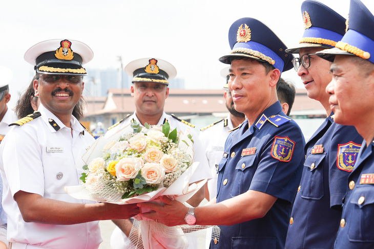 Thiếu tướng Ngô Bình Minh, tư lệnh Vùng cảnh sát biển 3, tặng hoa chúc mừng thuyền trưởng Sudhir Ravindran tại lễ đón tàu Samudra Paheredar - Ảnh: HỮU HẠNH