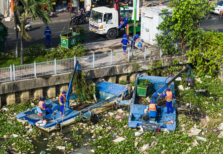 Công nhân vớt rác trên kênh Nhiêu Lộc - Thị Nghè (TP.HCM) - Ảnh: CHÂU TUẤN