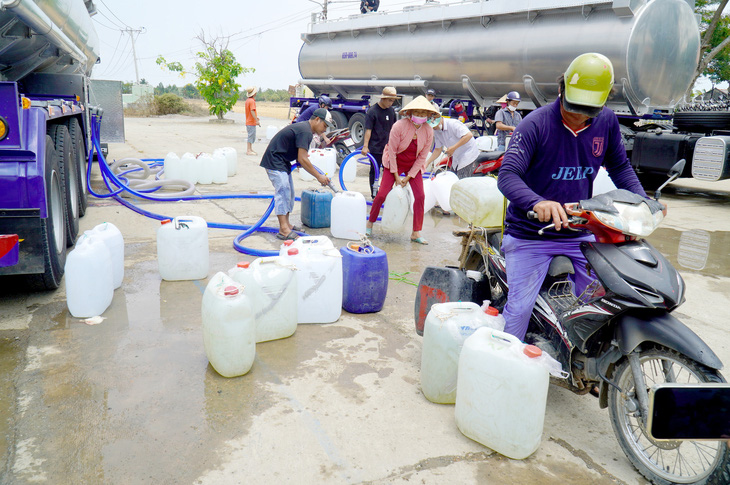Người dân huyện Gò Công Đông (Tiền Giang) đến các xe chở nước sạch miễn phí cung cấp cho bà con - Ảnh: MẬU TRƯỜNG
