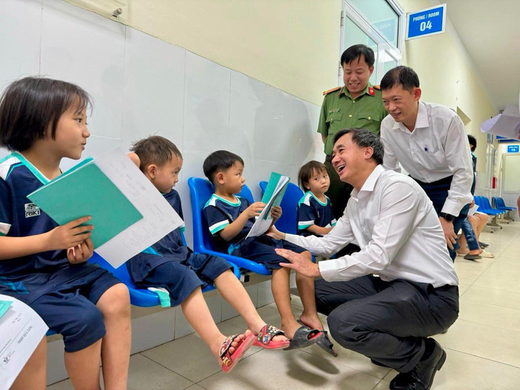 Thứ trưởng Bộ Y tế Trần Văn Thuấn tặng quà cho các bé đến khám sàng lọc miễn phí dịp này - Ảnh: BYT