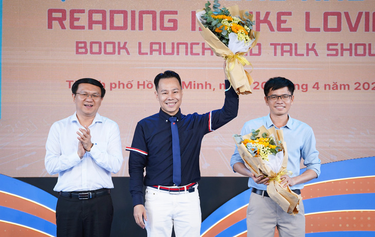 Giám đốc Sở Thông tin và Truyền thông TP.HCM Lâm Đình Thắng (bìa trái) tặng hoa cho tác giả Trung Nghĩa (giữa) - Ảnh: BTC