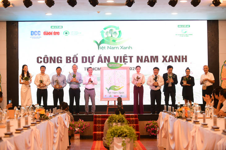 Nhà báo Trần Xuân Toàn - phó tổng biên tập báo Tuổi Trẻ tặng chậu cây xanh cho các khách mời - Ảnh: QUANG ĐỊNH