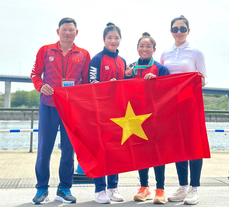 Nguyễn Thị Hương (thứ hai từ phải qua) và HLV, cán bộ môn đua thuyền sau khi giành vé đến Olympic tại Nhật Bản ngày 21-4 - Ảnh: TTVN