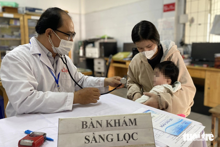 Khám sàng lọc cho trẻ trước khi tiêm vắc xin 5 trong 1 tại Trạm y tế xã Phú Xuân, huyện Nhà Bè (TP.HCM) - Ảnh: XUÂN MAI