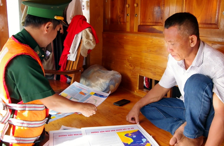 Bộ đội biên phòng tỉnh Bà Rịa - Vũng Tàu phát tờ rơi tuyên truyền phòng chống khai thác thủy sản trái phép cho ngư dân trước giờ ra khơi - Ảnh: ĐÔNG HÀ