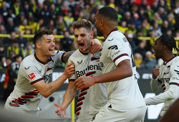 Josip Stanisic (giữa) giúp Leverkusen duy trì mạch bất bại - Ảnh: REUTERS
