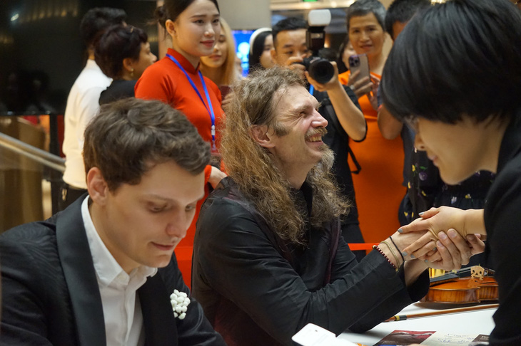 Nghệ sĩ Théo Imart (trái) và nhạc trưởng Stefan Plewniak ký tặng khán giả Hà Nội sau đêm hòa nhạc - Ảnh: T.ĐIỂU