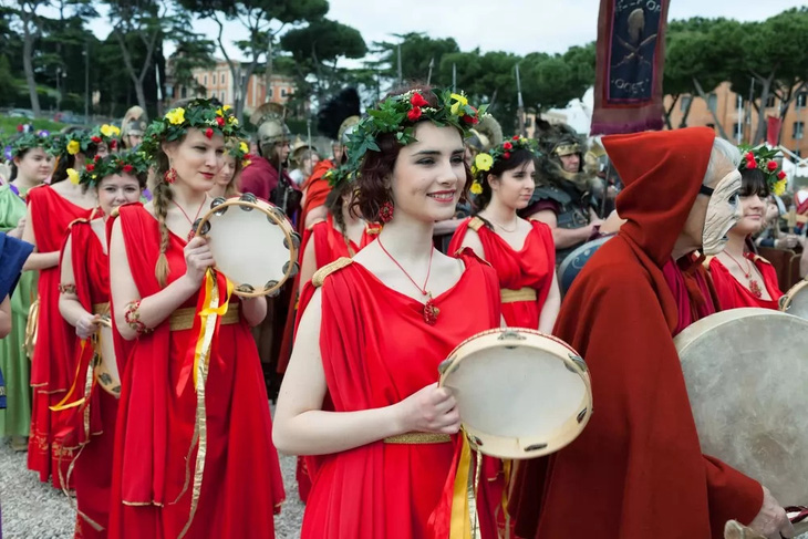 Các diễn viên tái hiện lễ hội cầu thần Pales (Palilia), nữ thần bảo vệ người chăn cừu và đàn cừu. Trong đó, các thiếu nữ mặc lễ phục thực hiện nghi thức phát rơm, tro và máu của những con vật bị hiến tế trước khi nhảy qua đống lửa ba lần - Ảnh: WANTED IN ROME