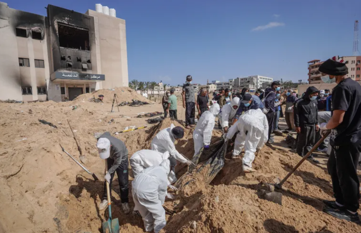 Các nhân viên y tế tại một mồ chôn tập thể nằm trong khuôn viên Khu liên hợp y tế Nasser, thành phố Khan Younis, Gaza ngày 21-4 - Ảnh: AFP