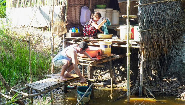 Người dân xã Khánh Thuận, huyện U Minh, tỉnh Cà Mau gạn từng thùng nước trong ao đìa để tắm gội, sinh hoạt - Ảnh: THANH HUYỀN