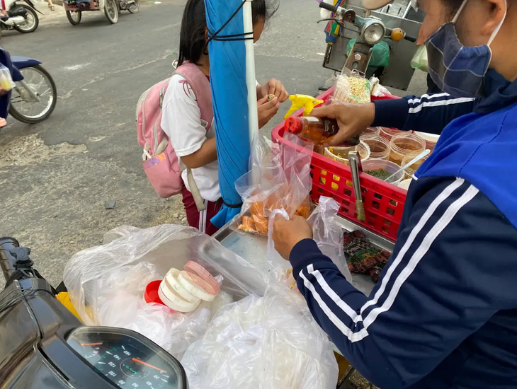 Bánh tráng trộn, bánh tráng cuốn đồng giá 5.000 đồng/bịch là món ăn quen thuộc của nhiều học sinh tại các trường học ở quận Bình Tân - Ảnh: VŨ HIÊN