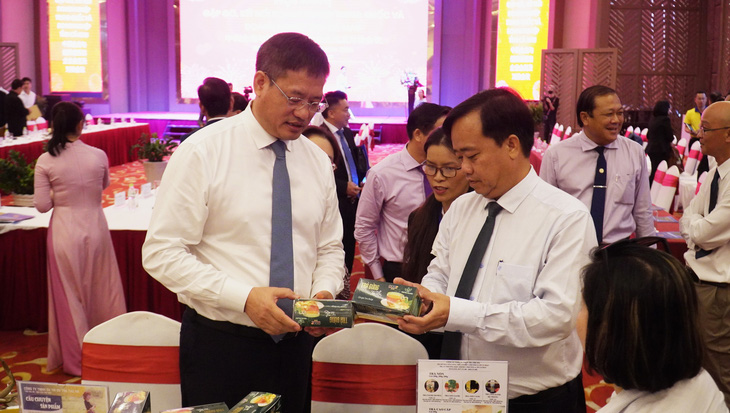 Ông Huỳnh Quốc Việt - chủ tịch UBND tỉnh Cà Mau (người cầm sản phẩm phía bên phải) và ông Ngụy Hoa Tường - Tổng lãnh sự quán Trung Quốc tại TP.HCM tham quan, kết nối với các doanh nghiệp trong tỉnh Cà Mau - Ảnh: THANH HUYỀN