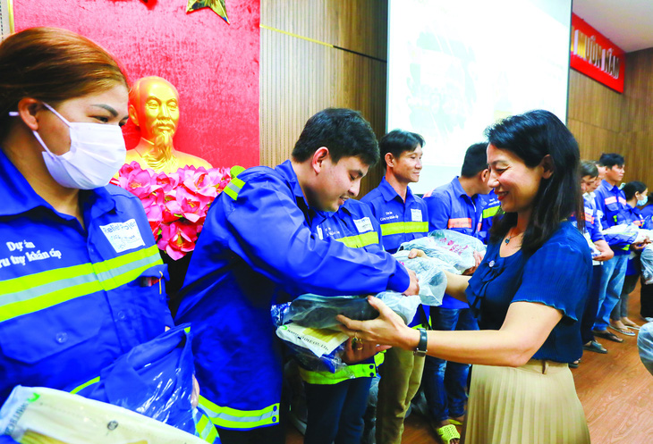 Bà Chu Thị Kim Thanh, giám đốc vận hành PRO Việt Nam, tặng trang bị bảo hộ cho người thu gom rác dân lập tại huyện Nhà Bè, TP.HCM.  Ảnh: LÊ PHAN